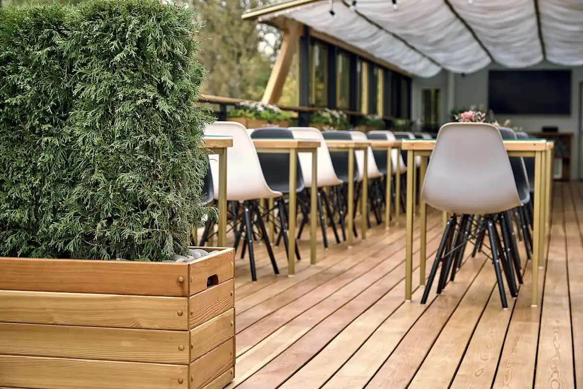 Une terrasse en bois avec des chaises et des tables