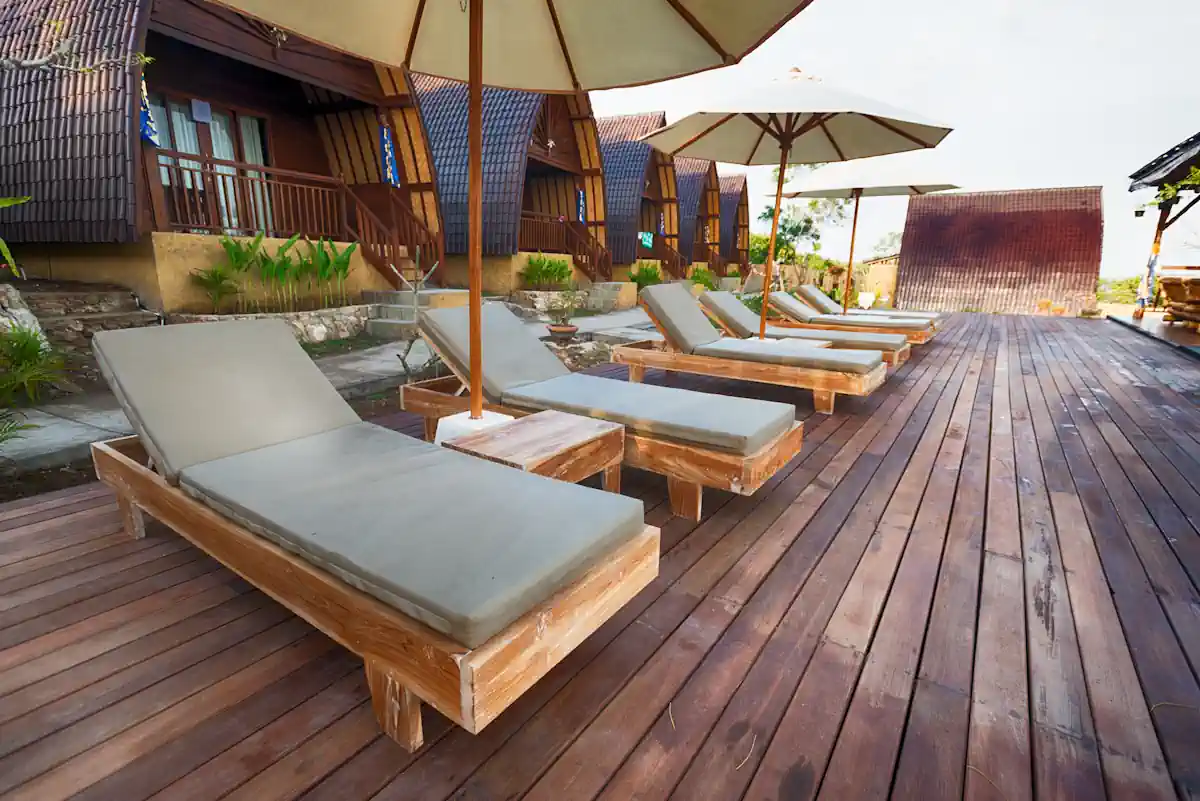 Une terrasse avec des lames en bois avec des transats et des parasols