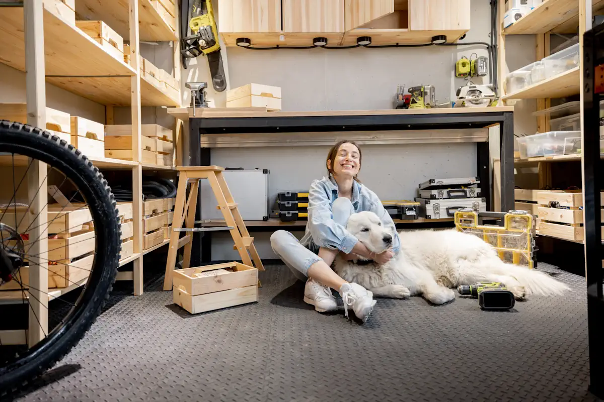 Une femme assise sur le sol d'un garage avec un chien