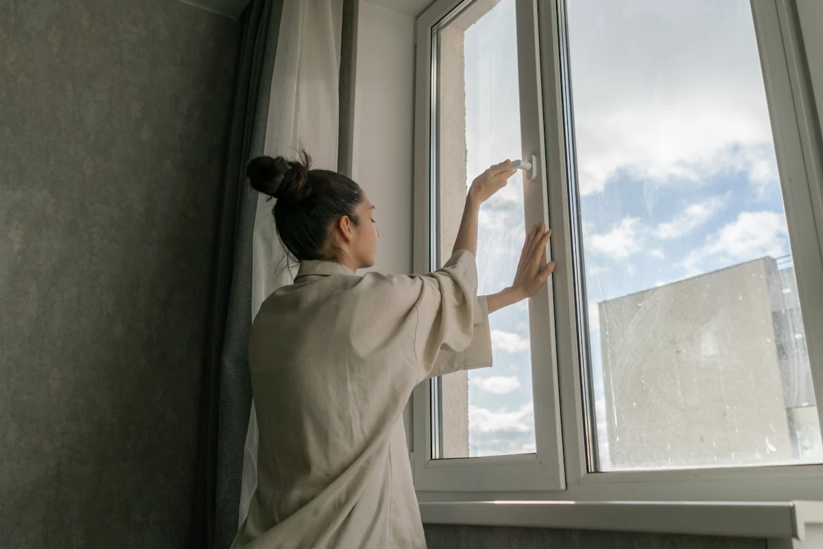 Une femme qui ouvre une fenêtre
