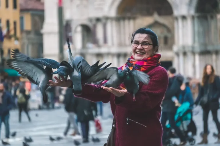 Une femme souriante qui tient des oiseaux dans sa main