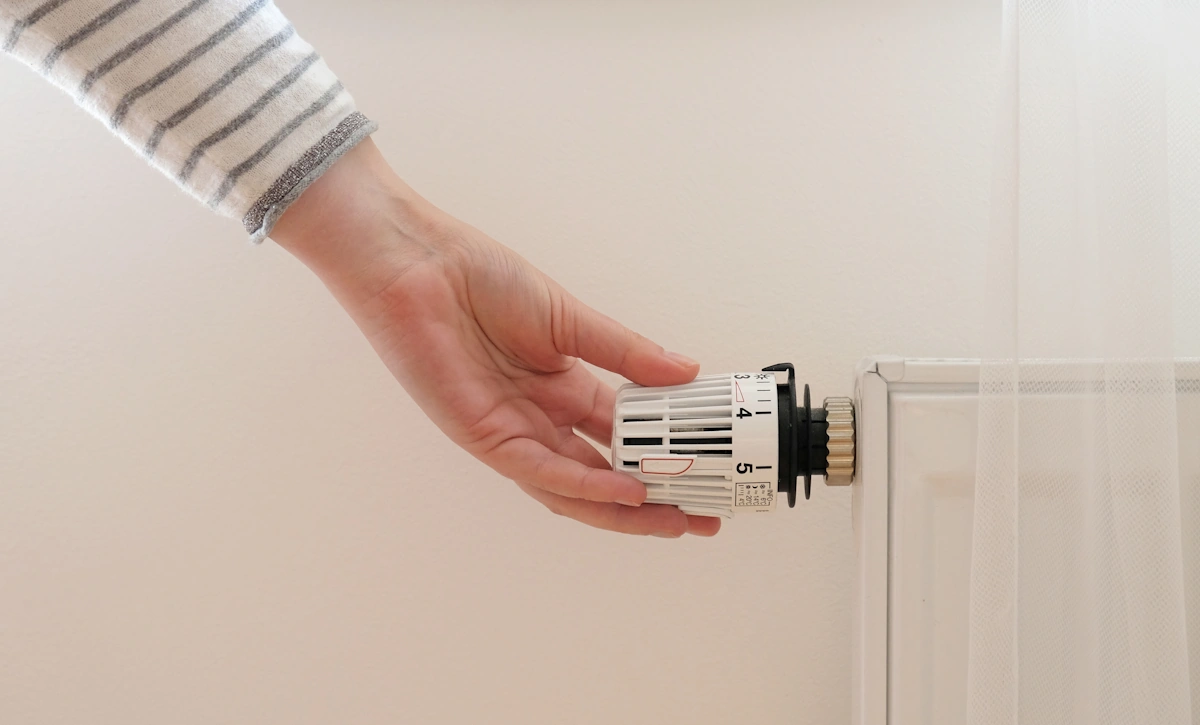 Une femme qui règle un radiateur
