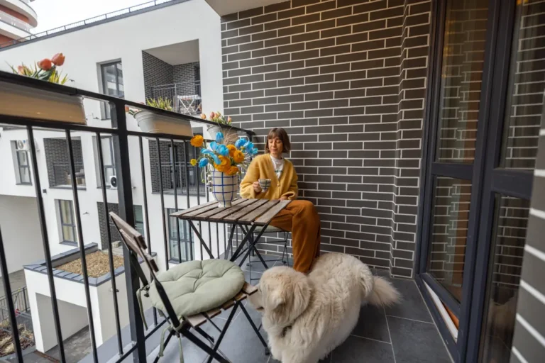 Une femme assise à son balcon avec son chien